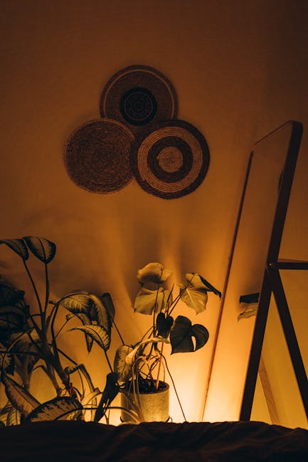 Sluoksniuotas interjero apšvietimas: lubinis, stalinė lempa ir akcentinė šviesa prie dekorų