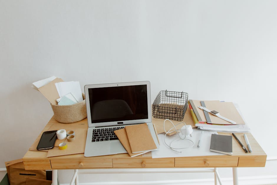 Tvarkingai suorganizuoti kabeliai po stalu su loveliais ir raiščiais mažame darbo kampelyje