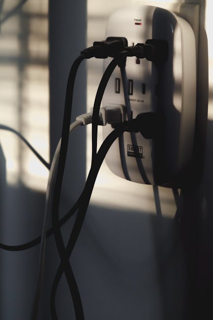 Žmogus išjungia prietaisą iš elektros lizdo, kad sumažintų budėjimo režimą